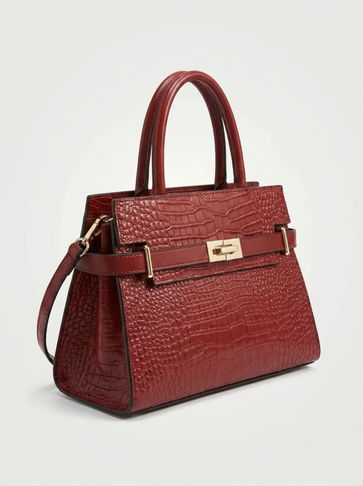 Sac en cuir rouge porté à l'épaule, silhouette entière