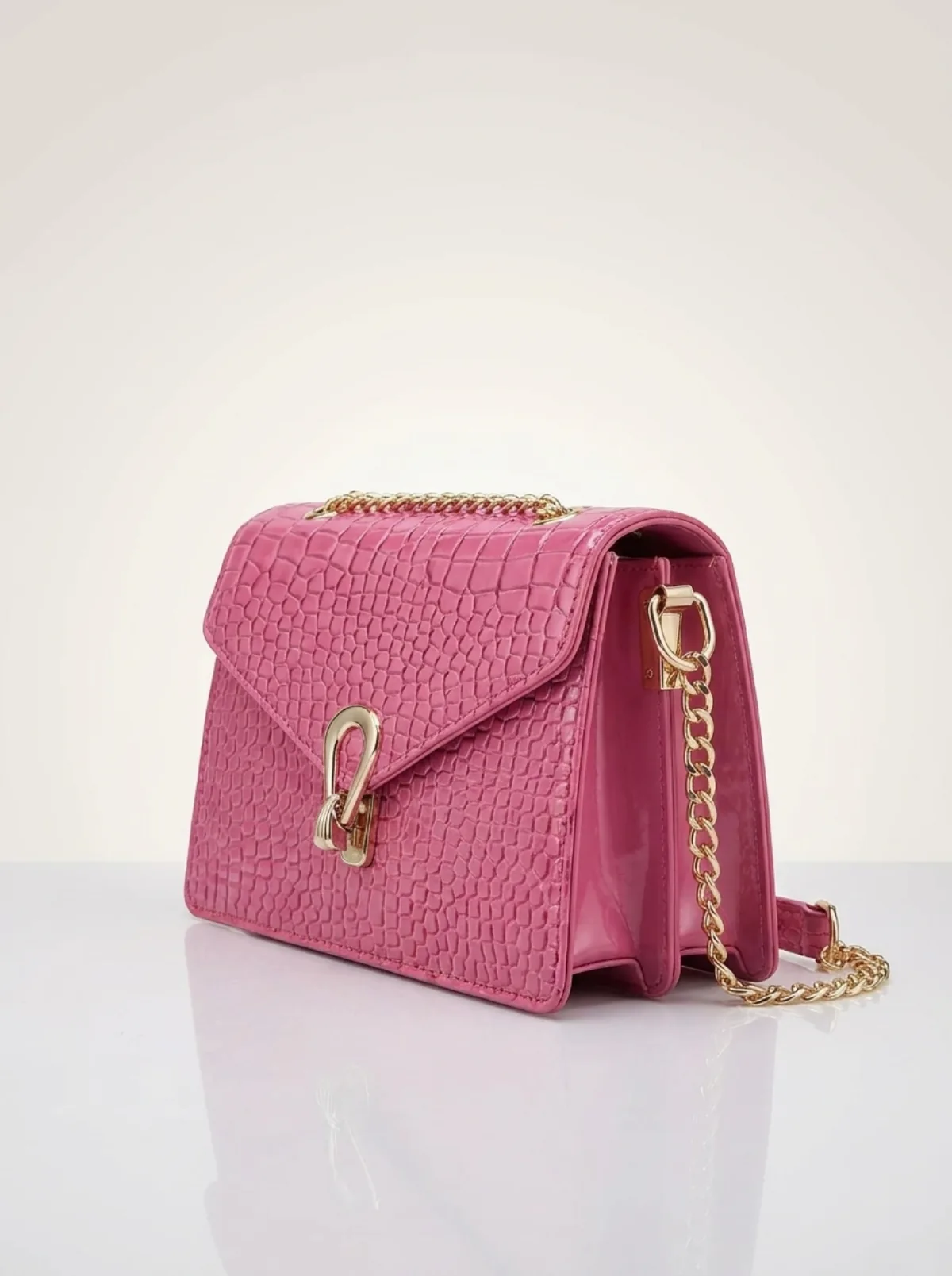 Petit sac en cuir rose posé avec un ruban, présentation cadeau