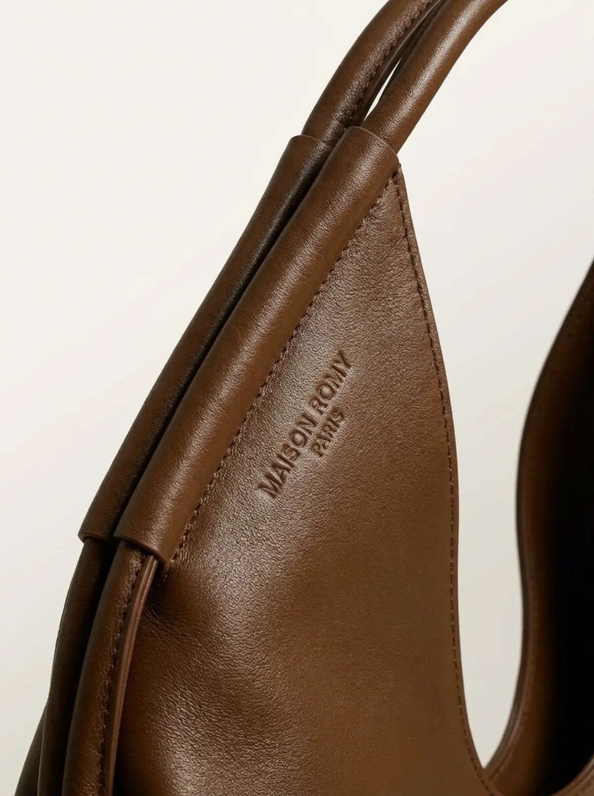 Sac à main en cuir fauve posé sur une surface naturelle